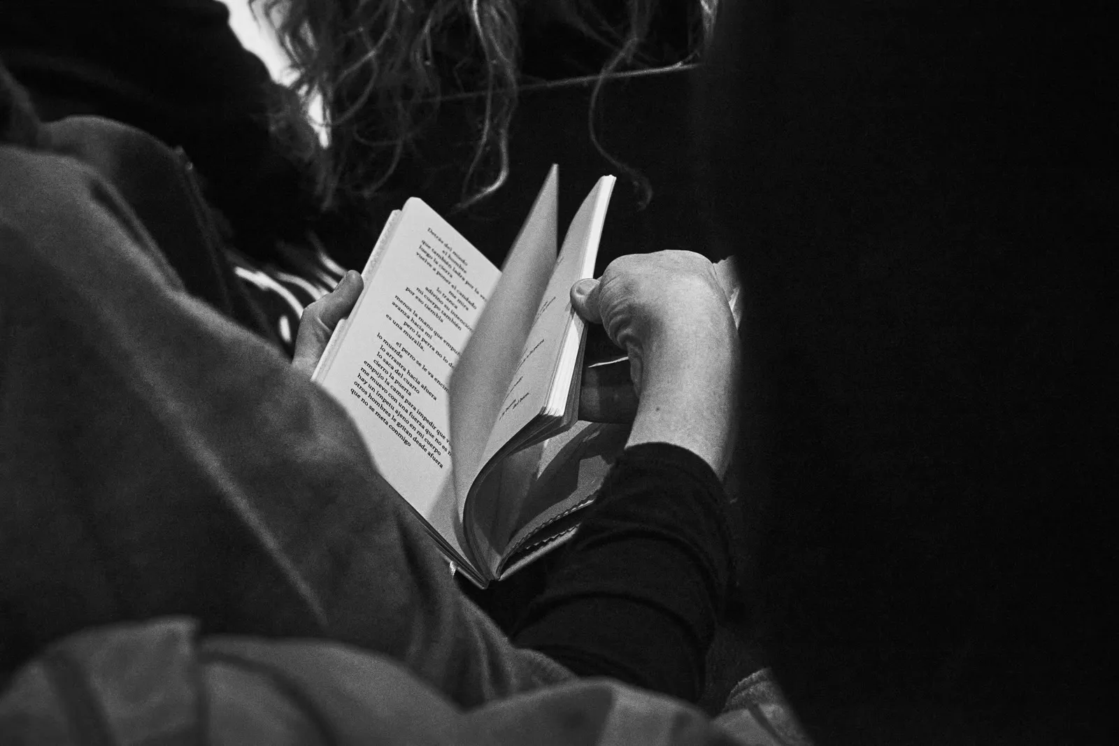 Manos sosteniendo el libro abierto